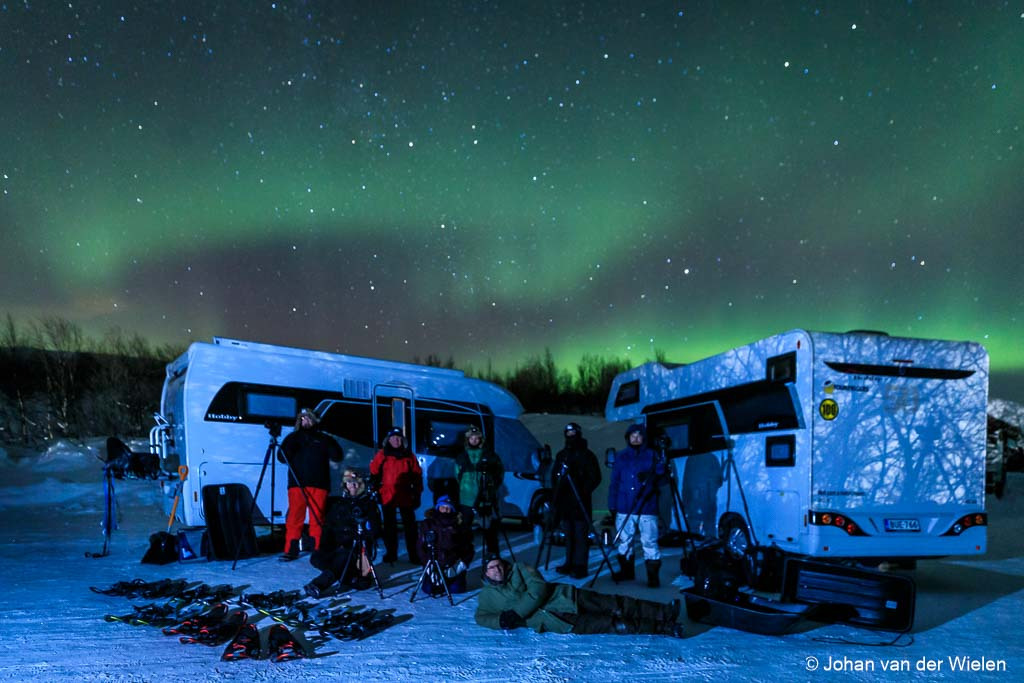 Arctic Aurora Chase 2019... the end of the trip but not of the pictures#aac2019Op dit moment zitten we de laatste spullen te pakken in ons guesthouse. Na een lange rit van bijna 600km gisteren van bijna Noordkaap terug naar de kop van Finland werden we gastvrij onthaald met kampvuur en rendierstoofpot bij -20. Wat een waanzinnige eind van een nog waanzinnigere reis!Helemaal fantastisch was het cadeautje van de groep: een ballon met een 2 en één met een 5 ... en sterretjes. Immers, dit was de 25e (!) reis die Finn Snaterse en ik samen hebben georganiseerd en begeleid sinds de eerste reis in 2010. Een mijlpaal en wat voor één.Komende week wordt het ploeteren door een enorme berg aan geweldige beelden tijdens ons 3000km (!) lange barre tocht met onze campers door Finland, Zweden en de kop van Noorwegen en daarnaast nog alle duizenden timelapse beelden, filmpjes van de groep en zelfs noorderlicht op film. Kortom, voorlopig zijn jullie nog niet van mij af als het om de beelden van de Arctic Aurora Chase gaat... één ding is zeker, deze reis was om te proberen maar gaat vanaf nu in het assortiment!Hierbij alvast één van de meest gave beelden die ik heb kunnen maken ,de groepsfoto in vol ornaat: campers, sneeuwschoenen, sleeën, statieven, noorderlicht, dikke kleding... en 8 gelukkige mensen. En dat alles bij -22.groet Johan van der Wielen