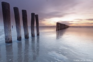 palen in de noordzee bij zonsondergang