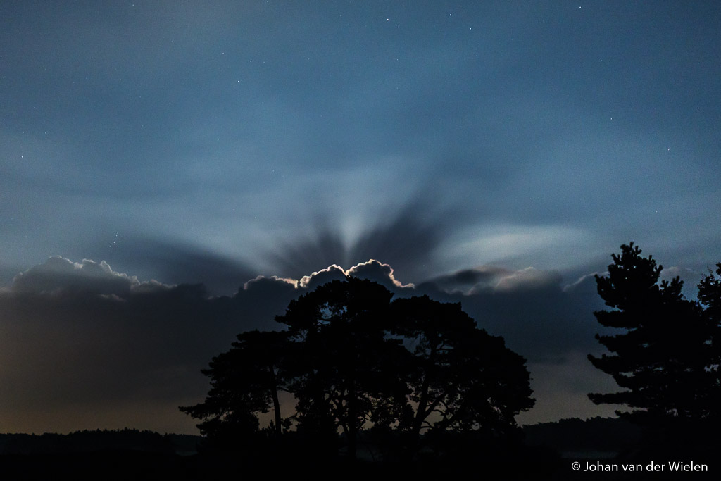 De volle maan straalt achter de laatste wolk