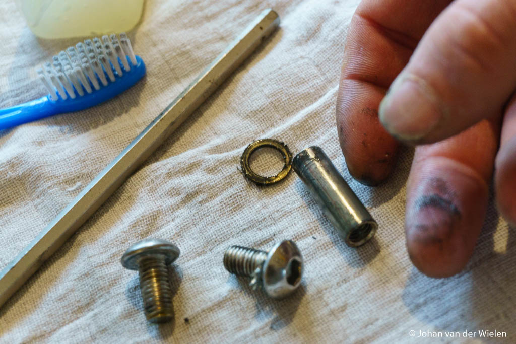 De scharnieren bestaan uit een busje, koperen ringen en een tweetal bouten. Mijn vingers laten duidelijk zien dat schoonmaken geen overbodige luxe is.
